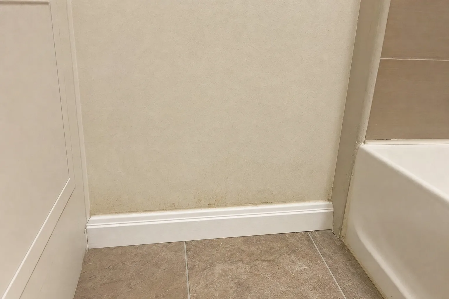 Lower bathroom wall near the tub where moisture readings were taken during the inspection.